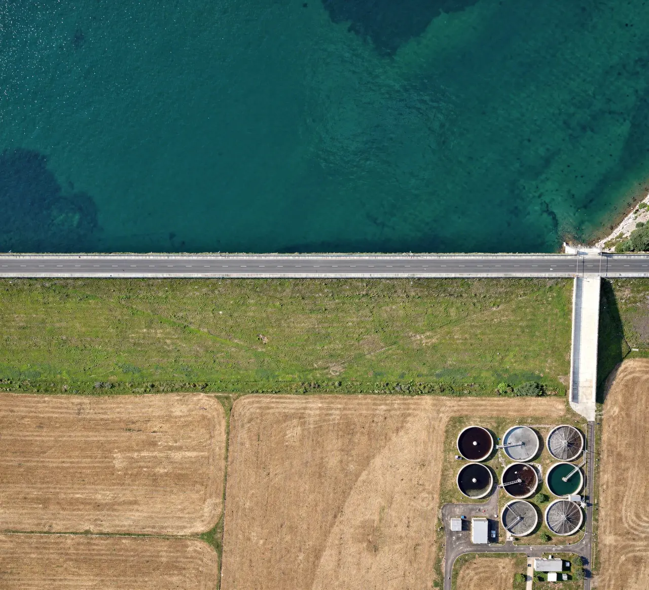 An overhead view of a reservoir, its embankment dam and a nearby water treatment works